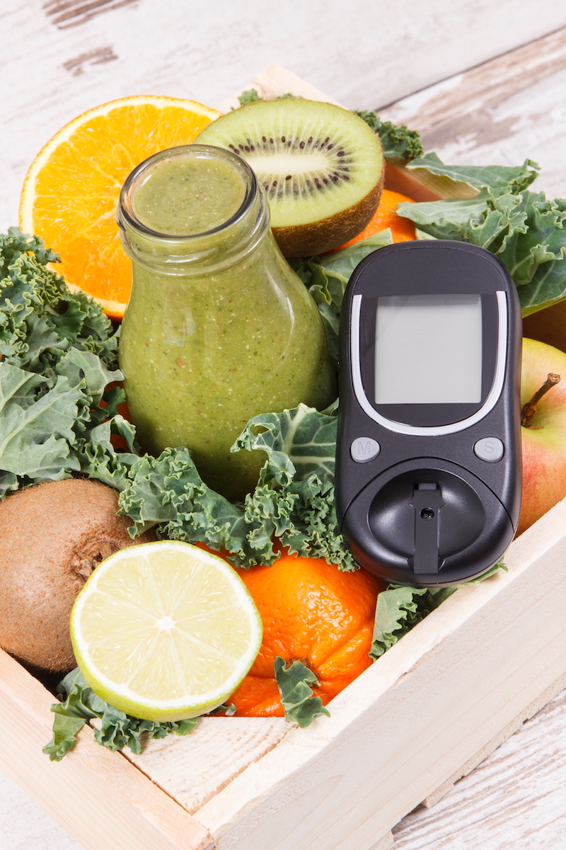Glucose meter for checking sugar level and freshly blended coctail from fruits and vegetables. Diabetes and healthy nutrition concept